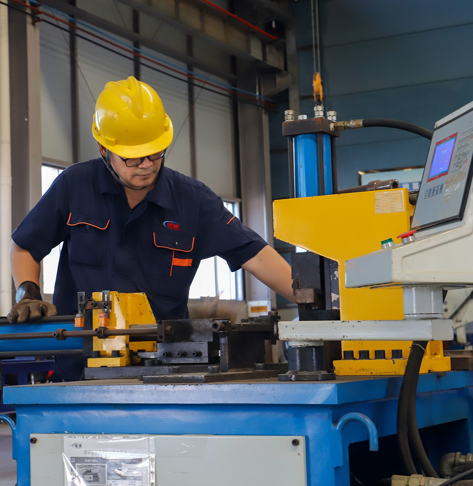 Worker operating rendering equipment inside animal fat processing plant
